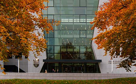 Autumnal coloured trees flanking a large glass window.